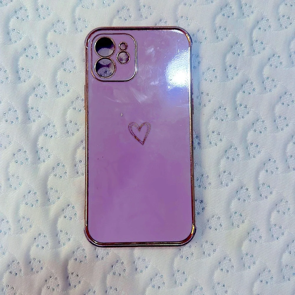 A light to medium purple LUTTY phone case with heart in the middle and designs